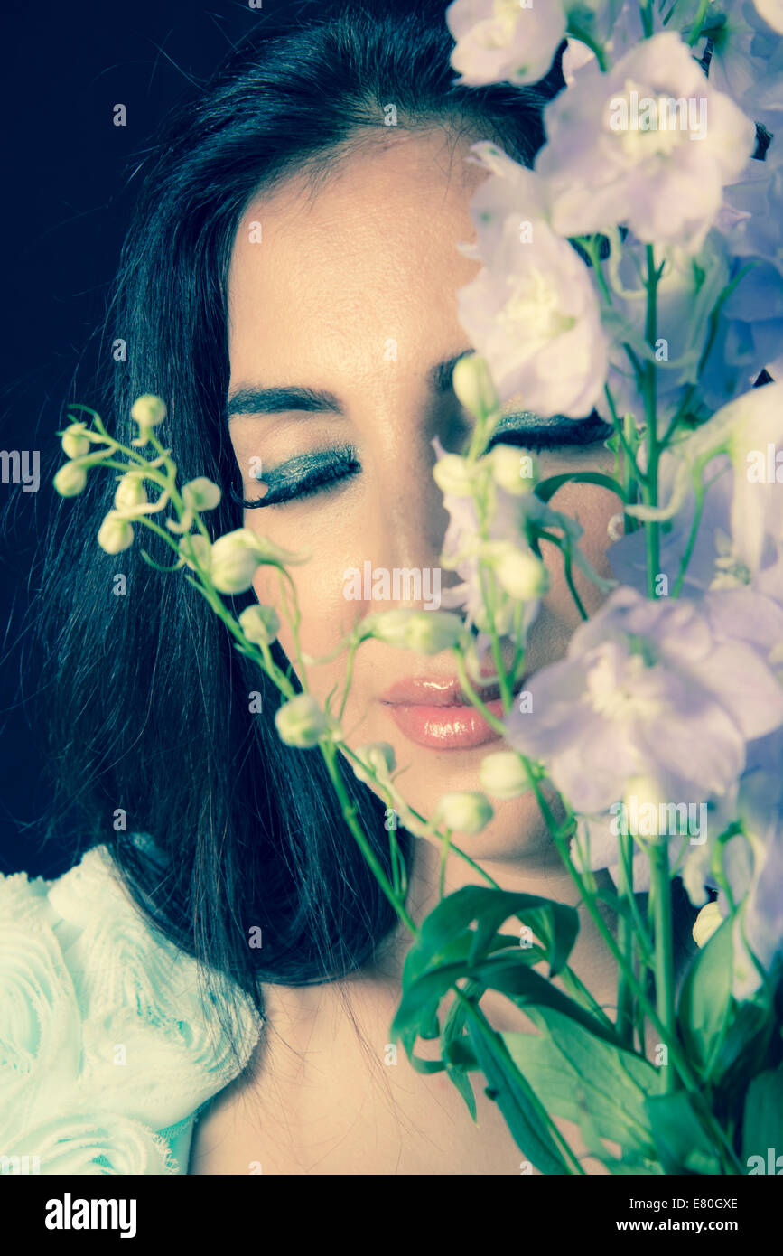 Woman holding flowers in front of her face Stock Photo