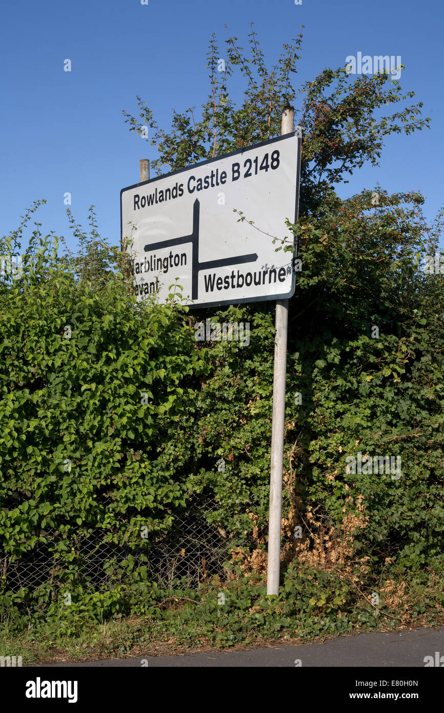 road sign in green hedge giving directions out of Emsworth on the B2148