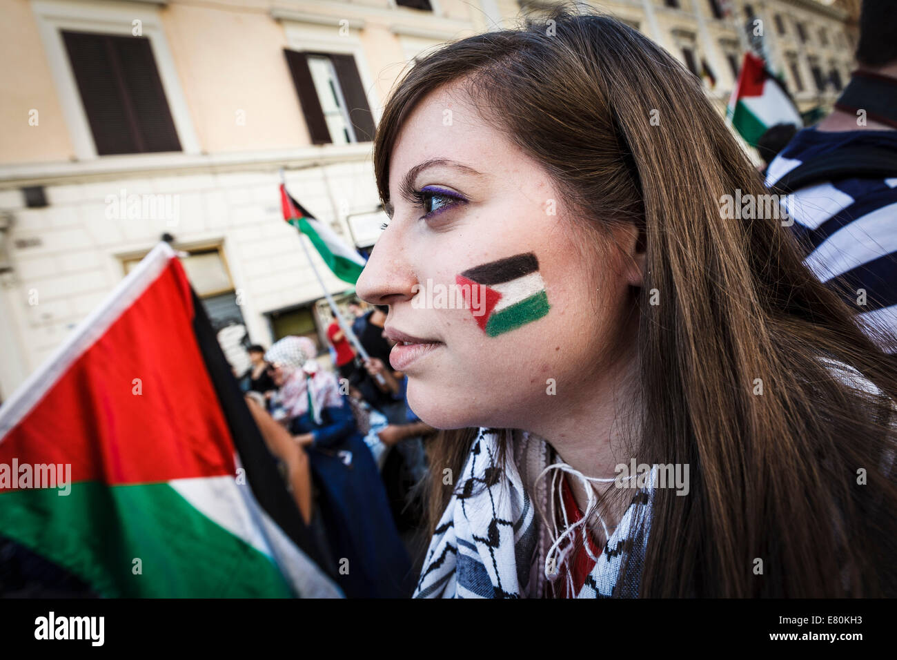 Demonstrator with her face painted in the colors of the Palestinian flag attends a pro-Palestinian rally in Rome to denounce Israel's military campaign in Gaza and to show their support to the Palestinian people. Thousands of people in Rome have rallied to express their protest against Israel's military operation in Gaza and to demand 'justice and freedom' for Palestine. Credit:  Giuseppe Ciccia/Pacific Press/Alamy Live News Stock Photo