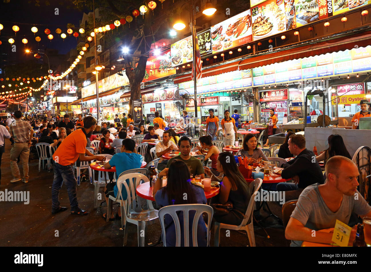People eating at outdoor restaurants and street food in Jalan Alor in