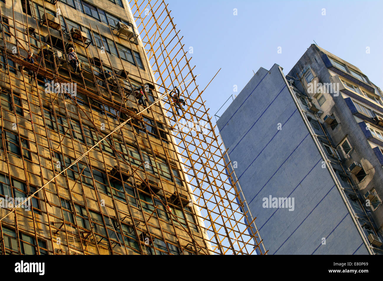 Chinese construction workers on bamboo scaffolding, Hong Kong, China. Stock Photo