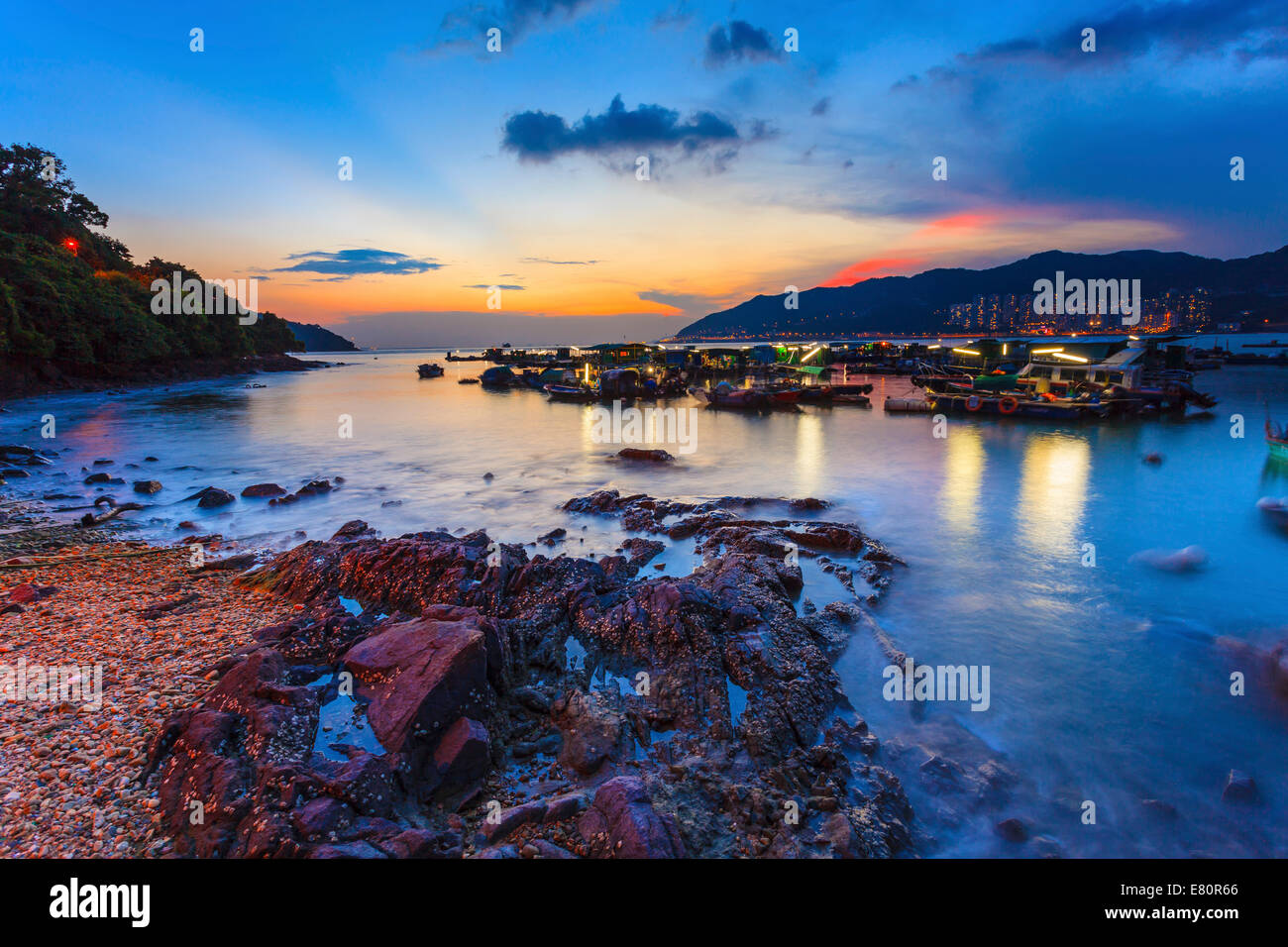 Sunset at coast with fishing boats Stock Photo - Alamy