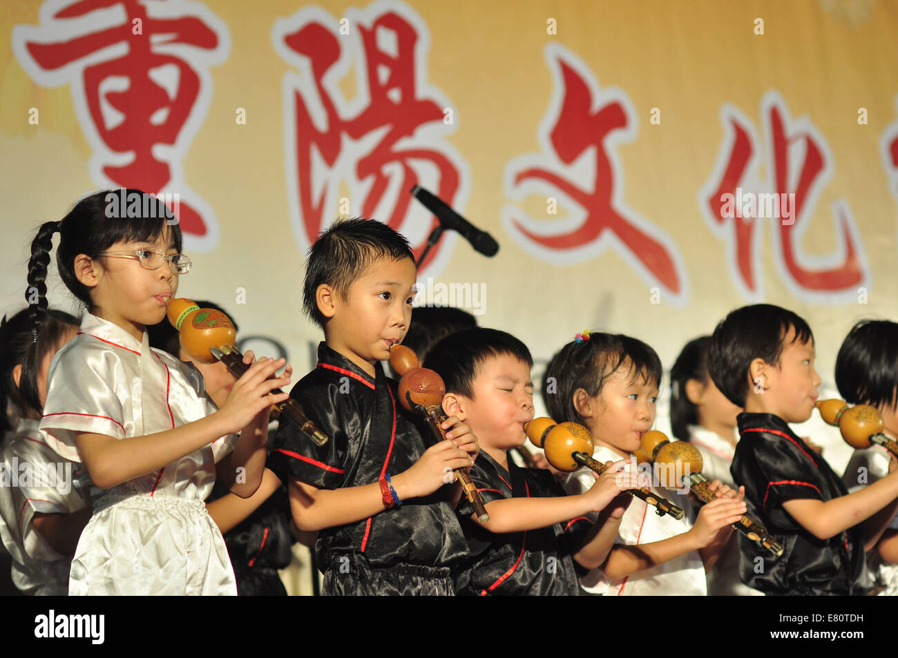 (140928) -- SELANGOR(MALAYSIA), Sept. 28, 2014 (Xinhua) -- Children play cucurbit flute during an activity marking the Double-Ninth Festival, or Chongyang Festival, a traditional Chinese festival, in Selangor, Malaysia, Sept. 28, 2014. (Xinhua/Chong Voon Chung) (lyi) Stock Photo