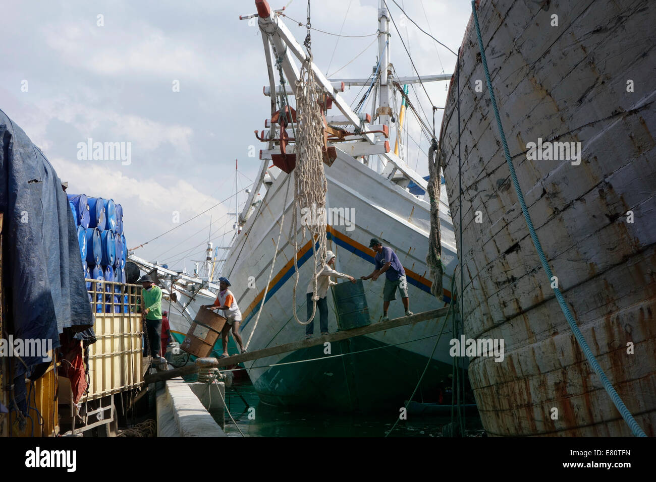 Men are loading the old boat with cargo for Borneo Stock Photo