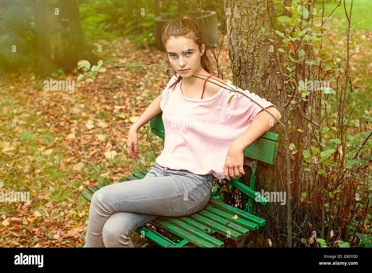 portrait of a strictly looking woman sitting on an old bench, toned image. Stock Photo