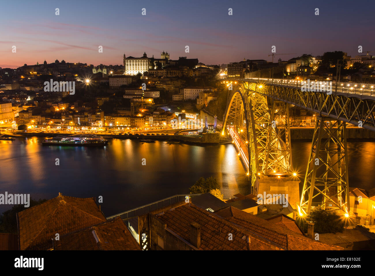 Sunset over the Ribeira district with the illuminated Luiz I bridge in foreground, Oporto, Portugal Stock Photo