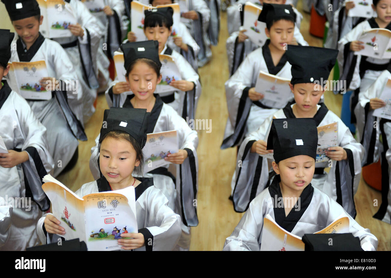 Hefei, China's Anhui Province. 28th Sep, 2014. Pupils wearing Hanfu, as ancient students did, recite Lunyu (or 'Analects' of Confucius) during a ceremony marking the 2565th birth anniversary of ancient Chinese philosopher Confucius in the Xiyou primary school in Hefei, capital of east China's Anhui Province, Sept. 28, 2014. Credit:  Liu Junxi/Xinhua/Alamy Live News Stock Photo