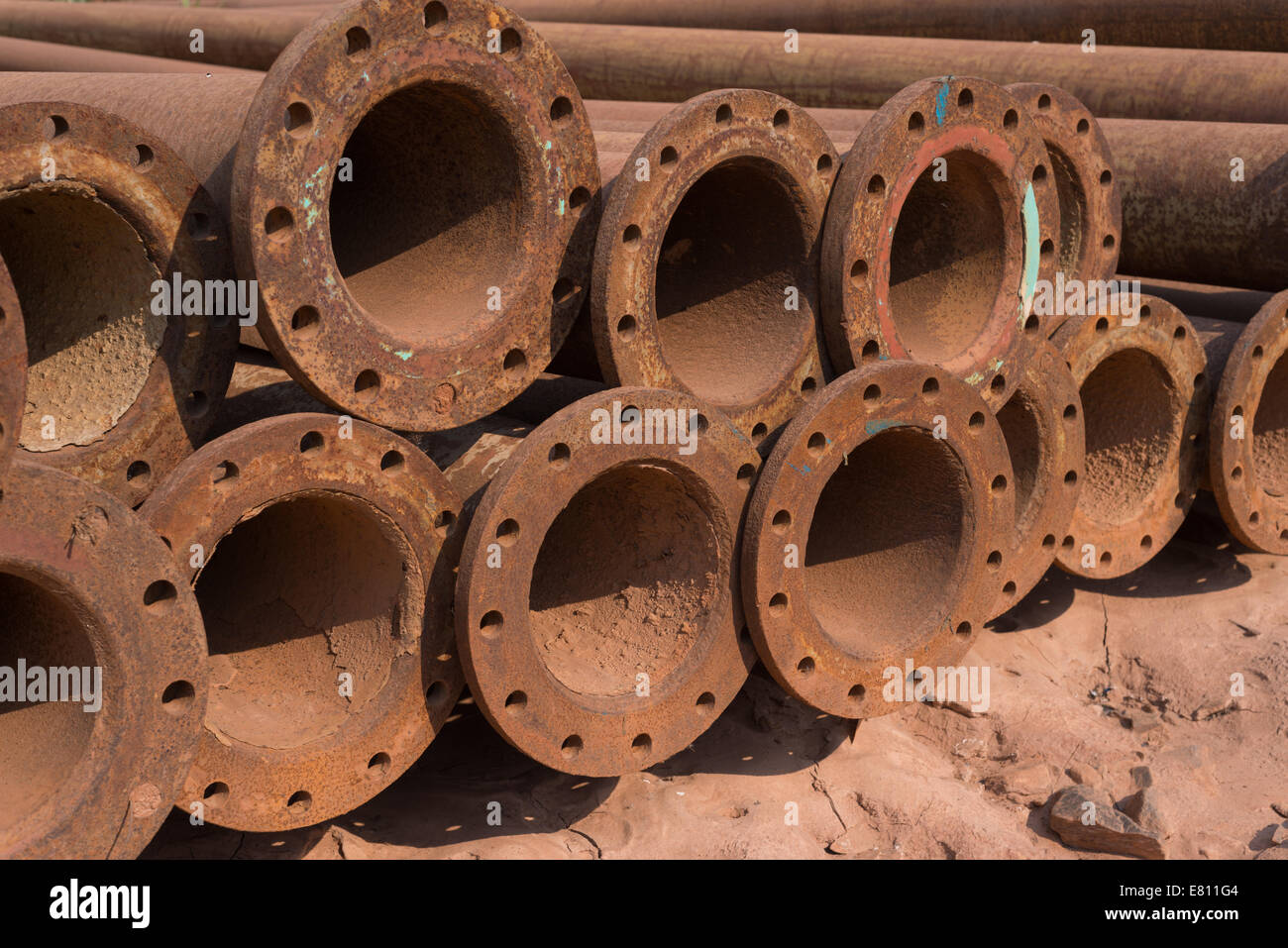 Used, abused and rusted steel pipes lie in the dirt of an African
