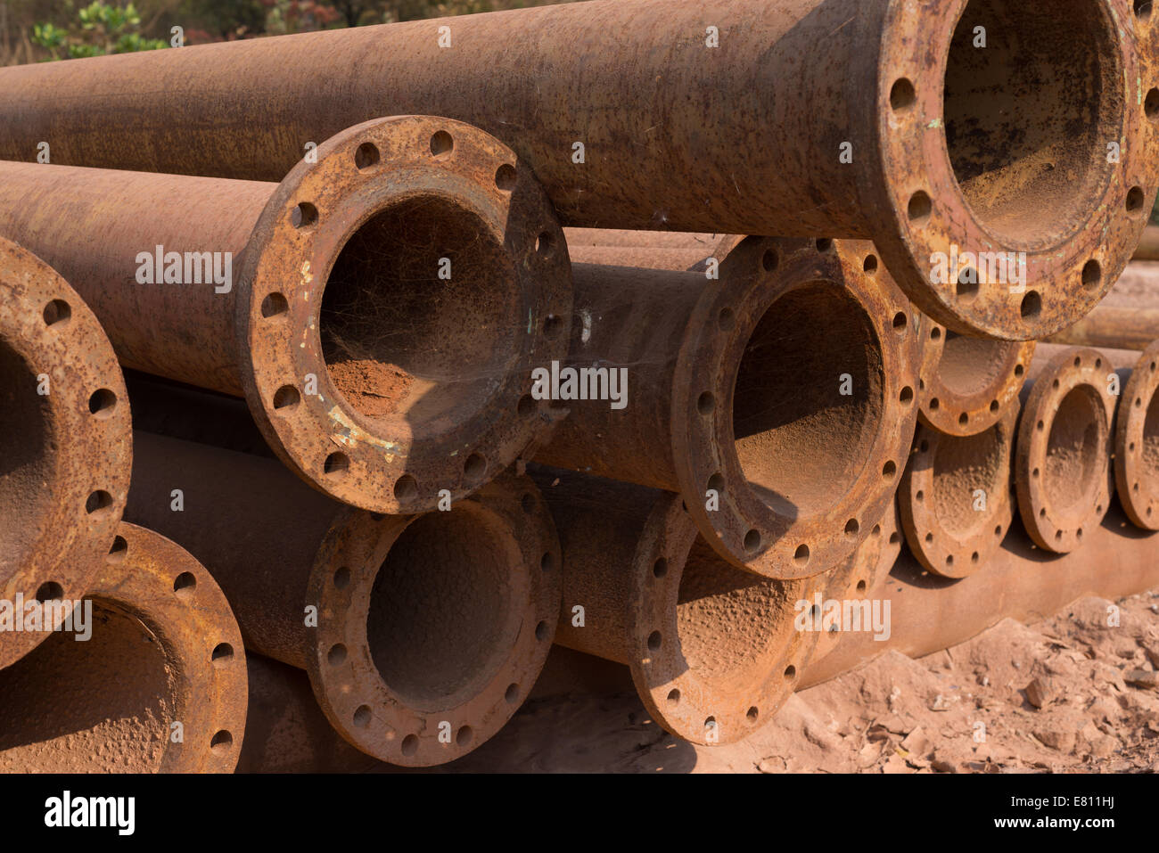 Steel pipes covered in spiders webs lie in a scrapyard of an African