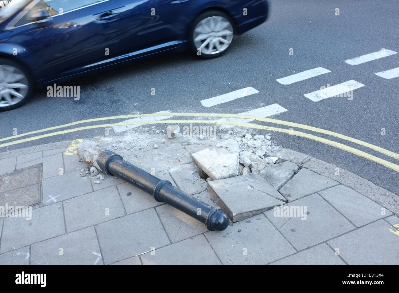 Street furniture damage with broken paving stones at road junction. Stock Photo