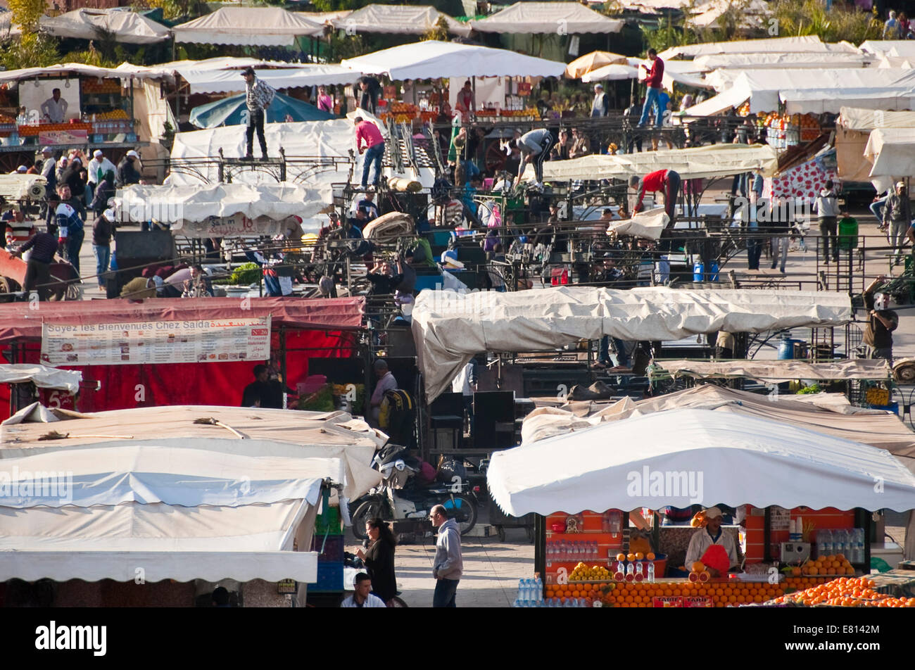Horizontal view of food stall holders setting up in Place Jemaa el-Fnaa in Marrakech. Stock Photo