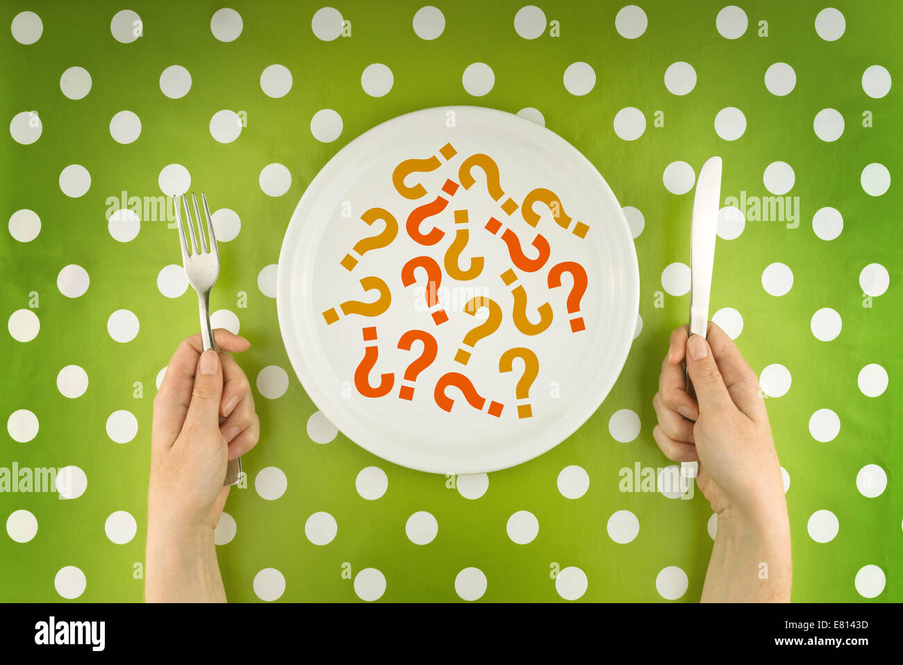 Woman eating question marks on a white plate, top view. Unknown or unrecognizable food concept. Stock Photo
