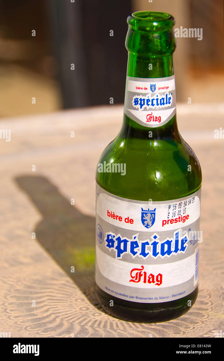 Vertical close up of an open bottle of Spéciale Flag Moroccan beer in the sunshine. Stock Photo