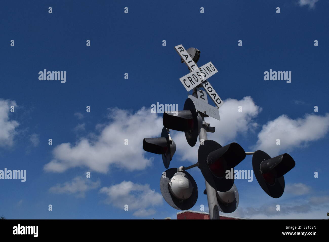 Railroad crossing sign with cloudy sky Stock Photo