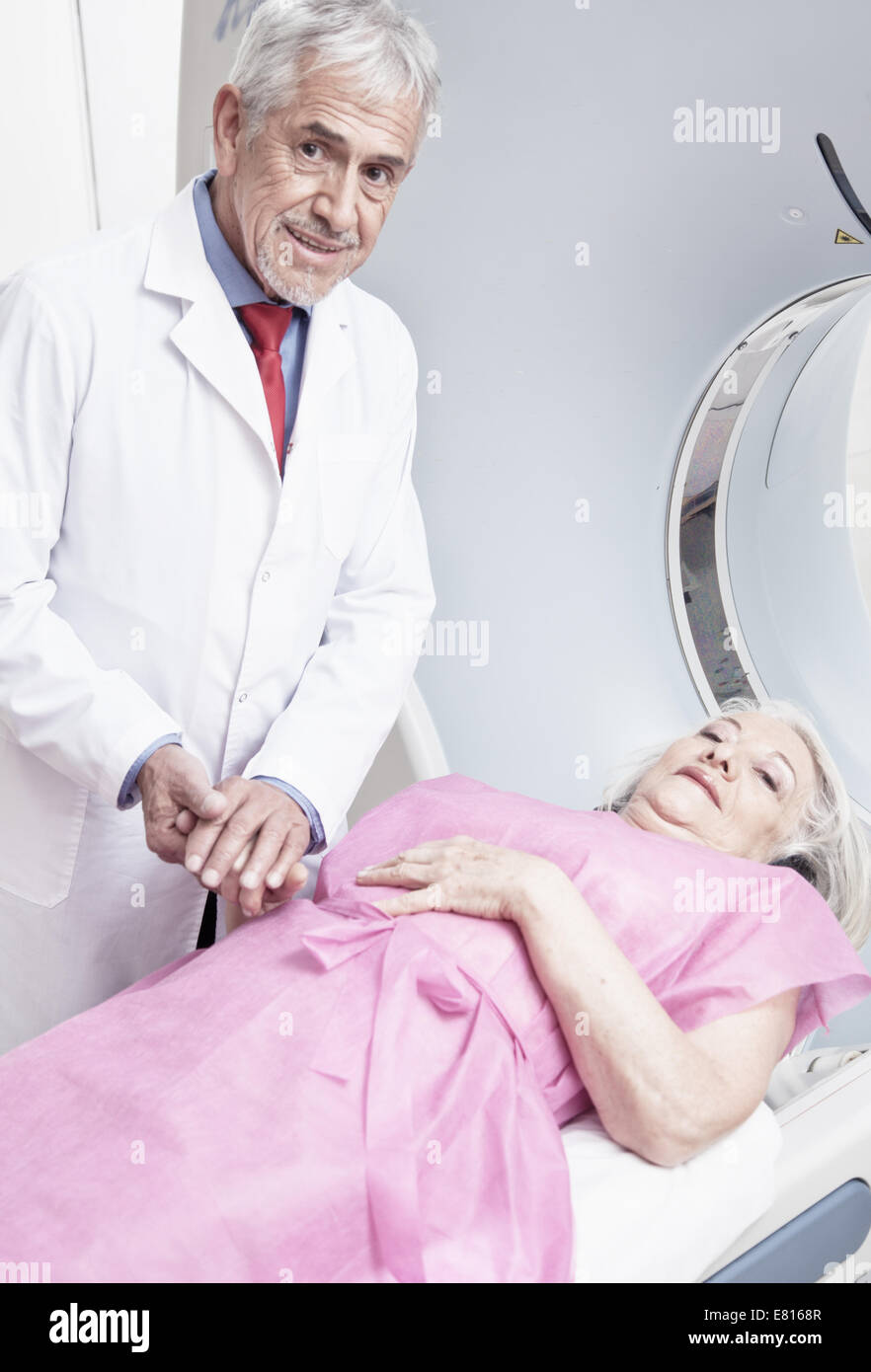 Male doctor reassuring female patient before computed tomography scan. Stock Photo