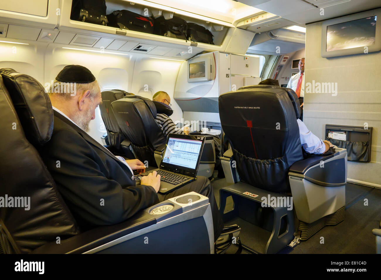 Miami Florida,International Airport,onboard,passenger cabin,American Airlines,class,seats,adult adults man men male,Jewish,wearing cap,yarmulke,kippah Stock Photo