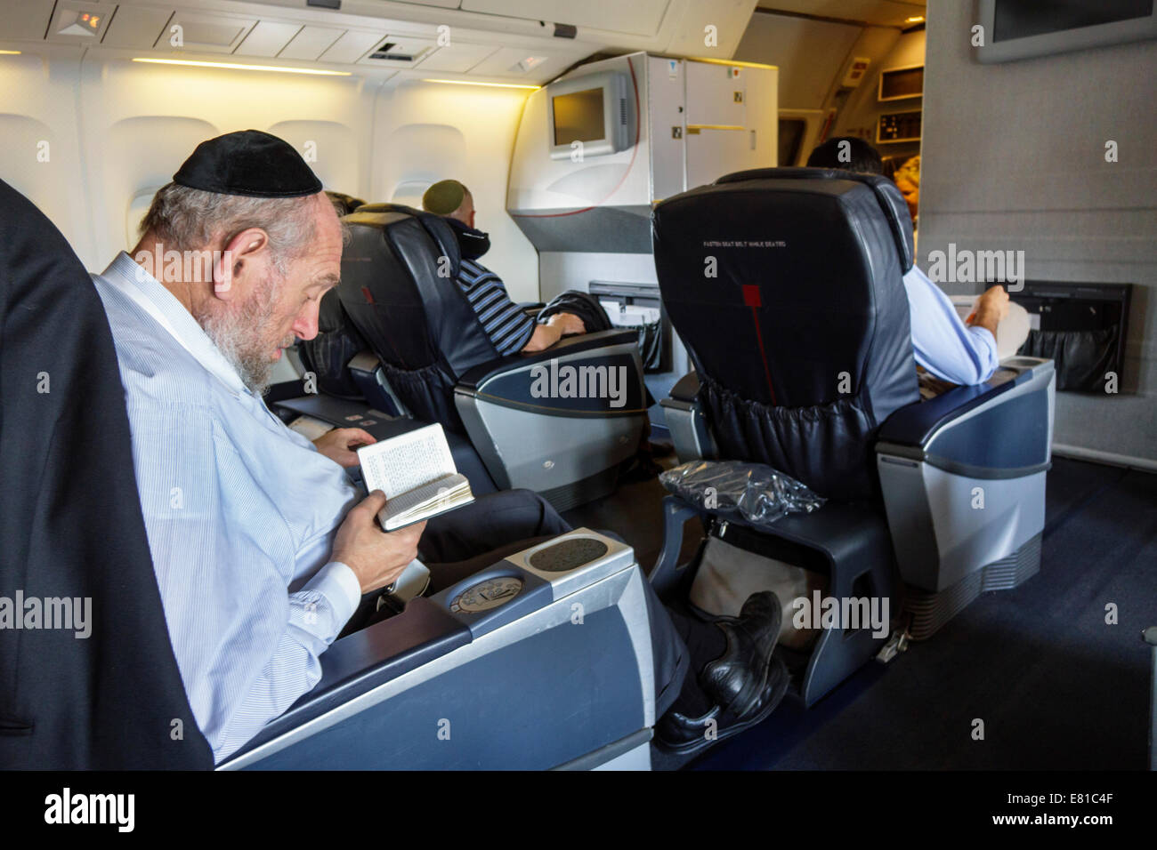 Miami Florida,International Airport,onboard,passenger cabin,American Airlines,class,seats,adult adults man men male,Jewish,wearing cap,yarmulke,kippah Stock Photo
