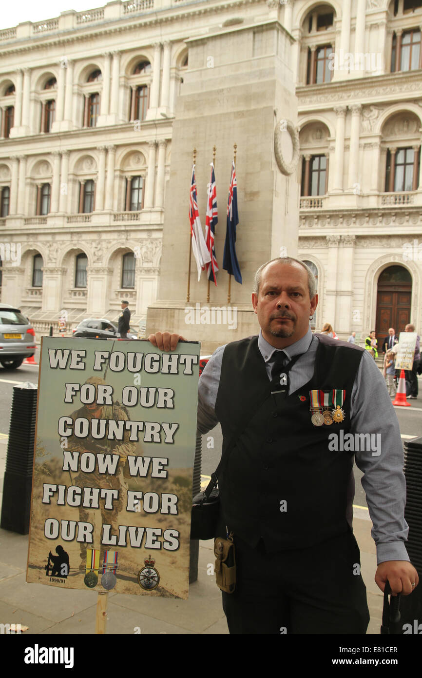 London, UK. 27th Sep, 2014.  Julian Pope who served with the 14th/20th King's Hussars at the Gulf War for 5 months holds a placard at the Gulf War Syndrome demo at Whitehall  Julian suffer from multiple ailments following a concottion of untested vaccines adminstered before the war.. Credit:  david mbiyu/Alamy Live News Stock Photo