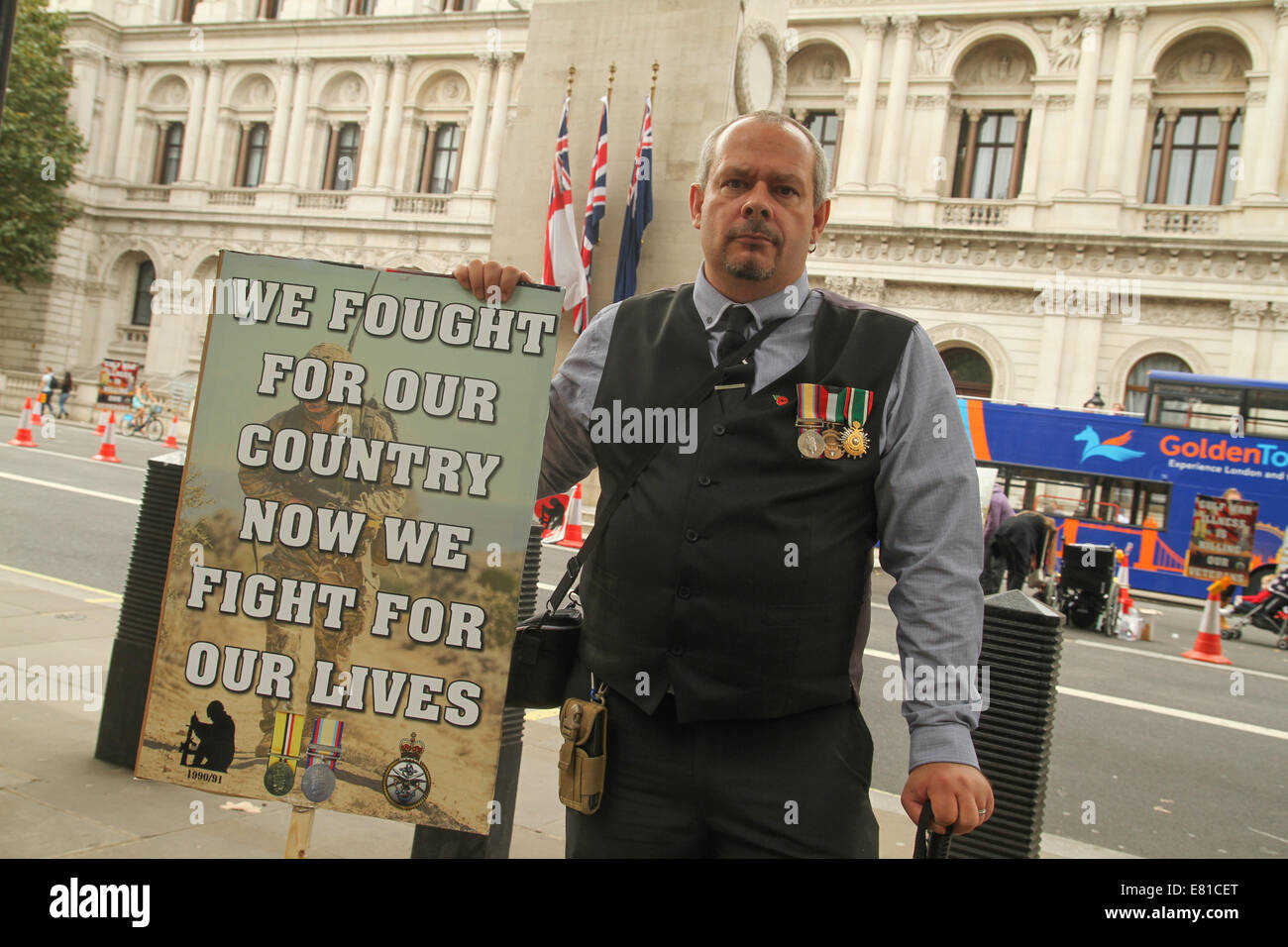 London, UK. 27th Sep, 2014.  Julian Pope who served with the 14th/20th King's Hussars at the Gulf War for 5 months holds a placard at the Gulf War Syndrome demo at Whitehall  Julian suffer from multiple ailments following a concottion of untested vaccines adminstered before the war.. Credit:  david mbiyu/Alamy Live News Stock Photo