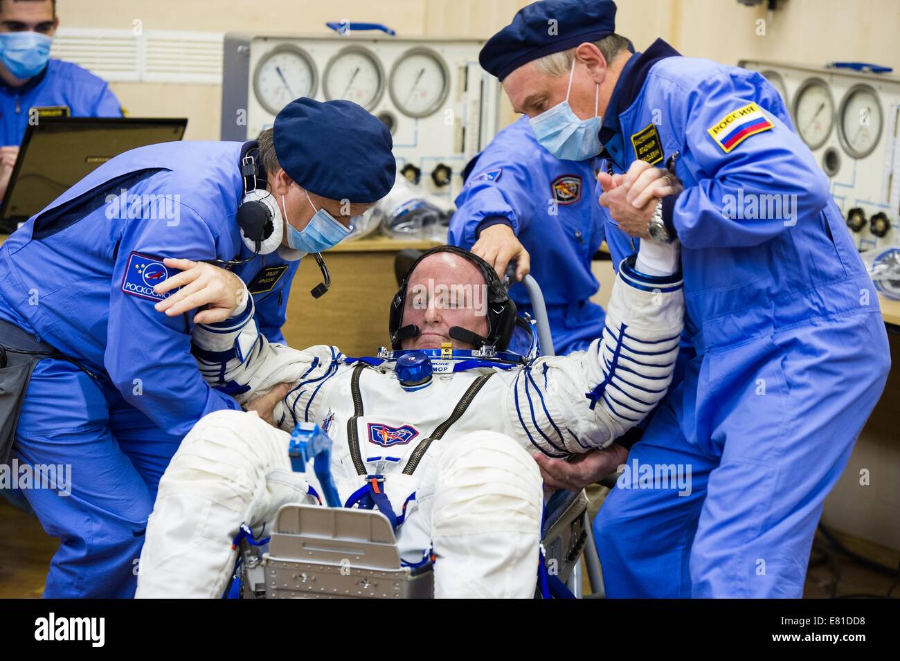 International Space Station Expedition 41 astronaut Barry Wilmore of NASA is helped up after completing the pressure check on his Russian Sokol space suit in preparation for launch aboard the Soyuz TMA-14M spacecraft to the International Space Station September 25, 2014 in Baikonur, Kazakhstan. Samokutyaev, Serova and Wilmore will spend the next five and a half months living and working aboard the ISS. Stock Photo