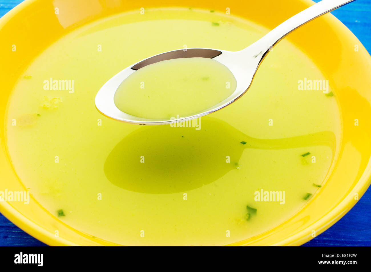 Spinach soup in a yellow plate. View on a spoon. Stock Photo