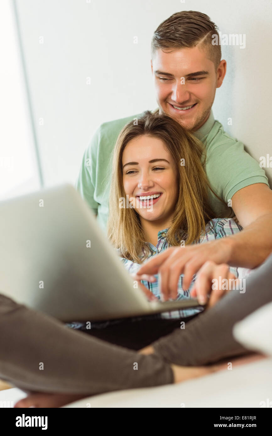 Cute couple relaxing on couch with laptop Stock Photo - Alamy
