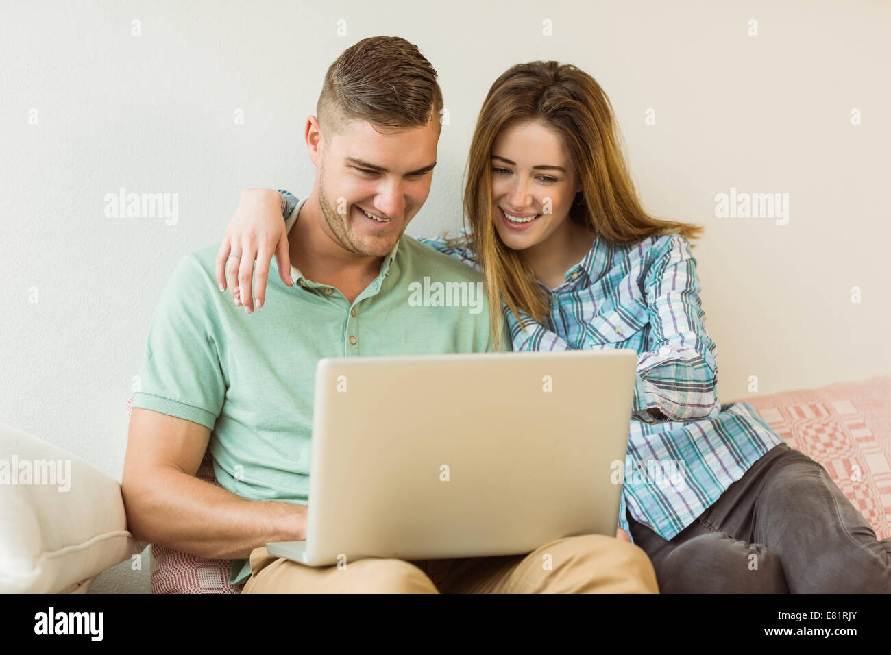 Cute couple relaxing on couch with laptop Stock Photo - Alamy