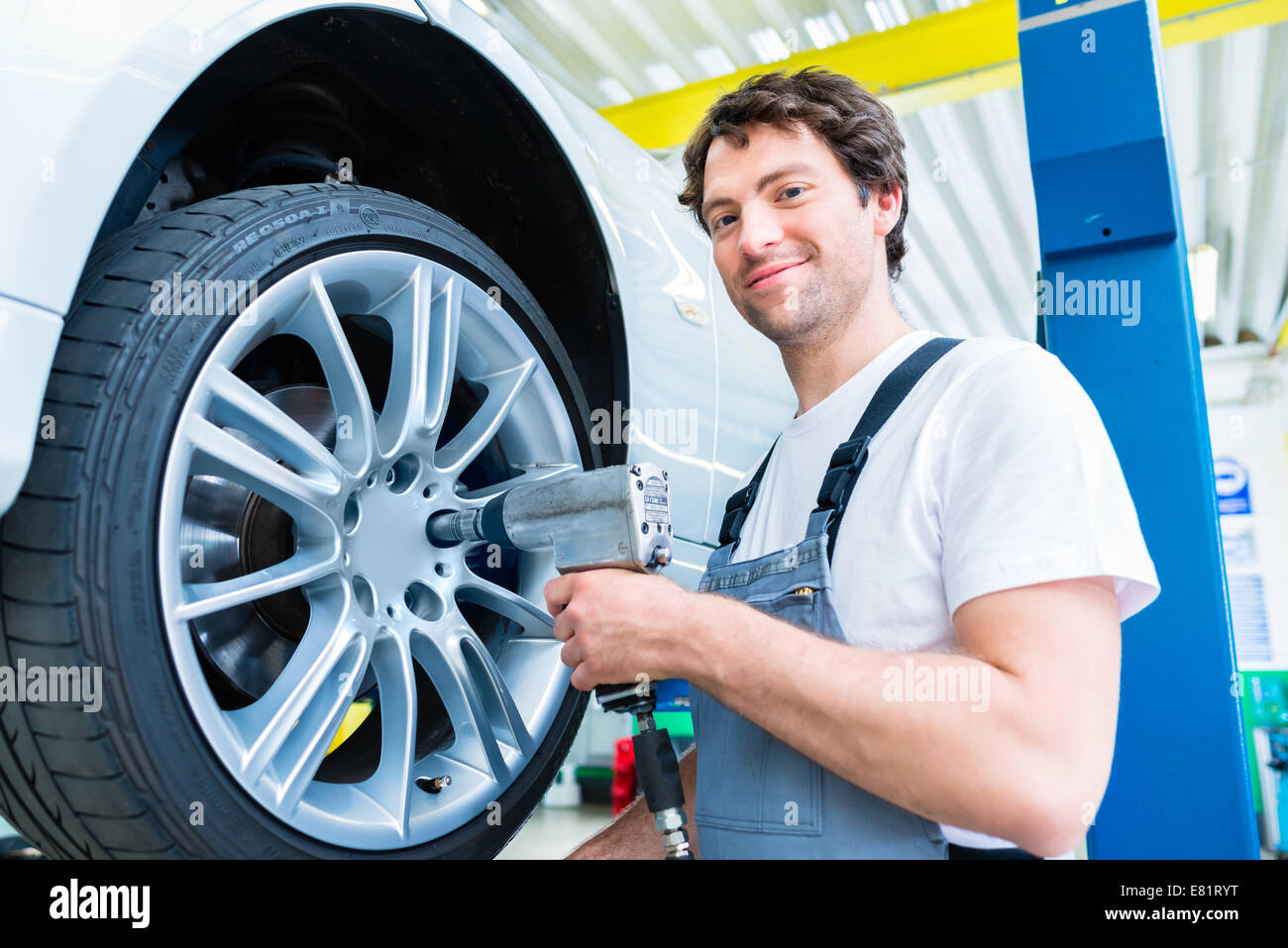 Male mechanic changing car tire or tyre in Stock Photo Alamy