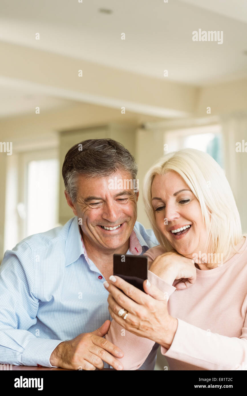 Happy mature couple looking at smartphone together Stock Photo