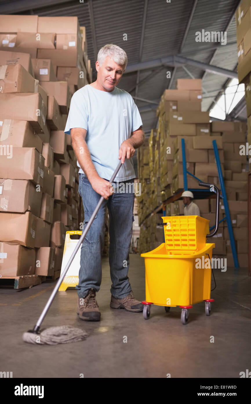 Man moping warehouse floor Stock Photo - Alamy