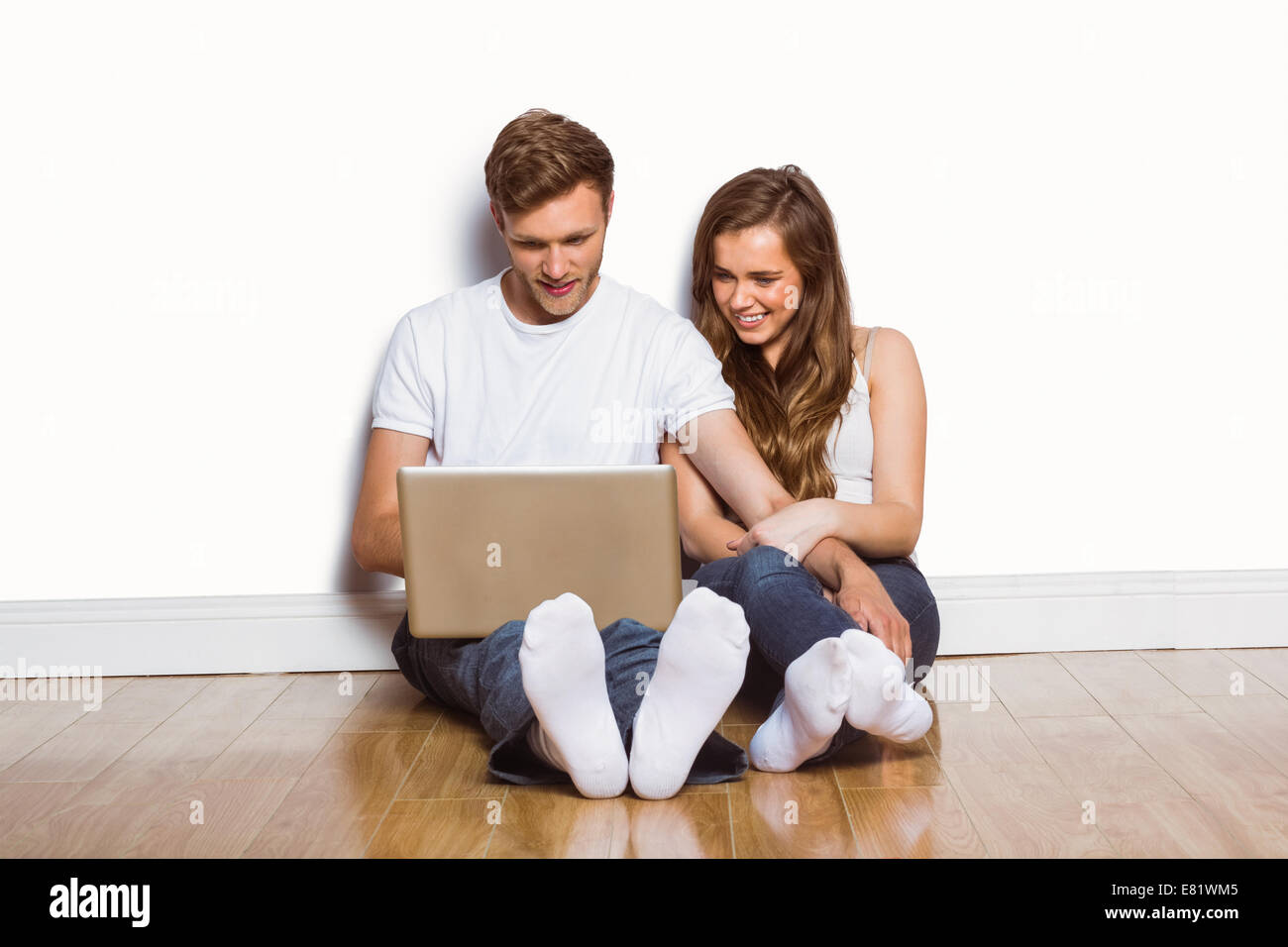 Young couple using laptop on floor Stock Photo - Alamy