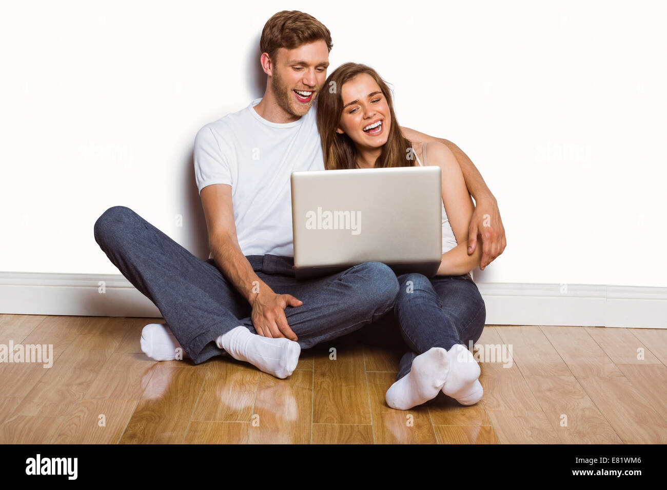 Young couple using laptop on floor Stock Photo - Alamy