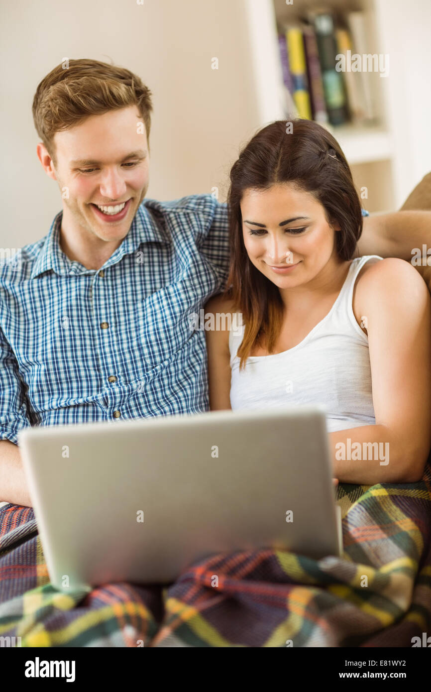 Happy young couple relaxing on the couch with laptop Stock Photo - Alamy