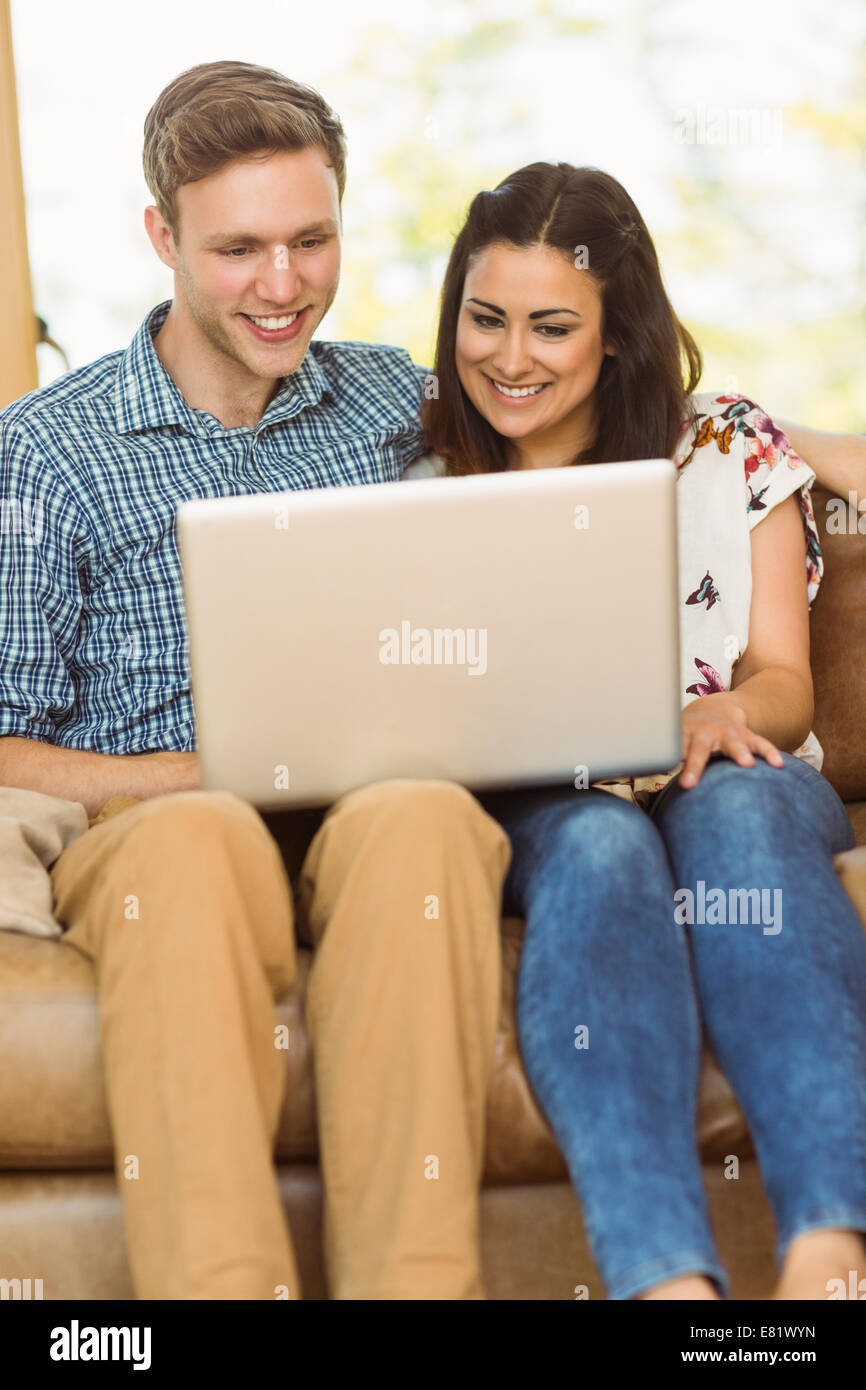 Young cute couple relaxing on couch with laptop Stock Photo - Alamy