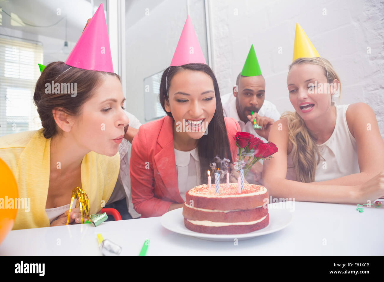 Businesswoman blowing the candles on her birthday cake Stock Photo - Alamy