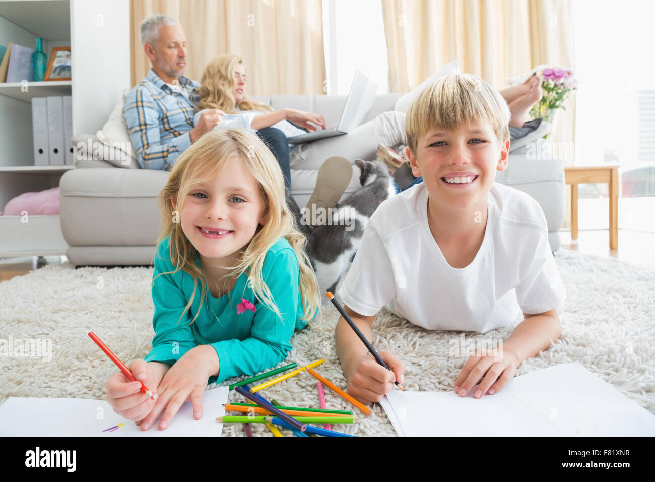Siblings colouring and drawing on the floor Stock Photo