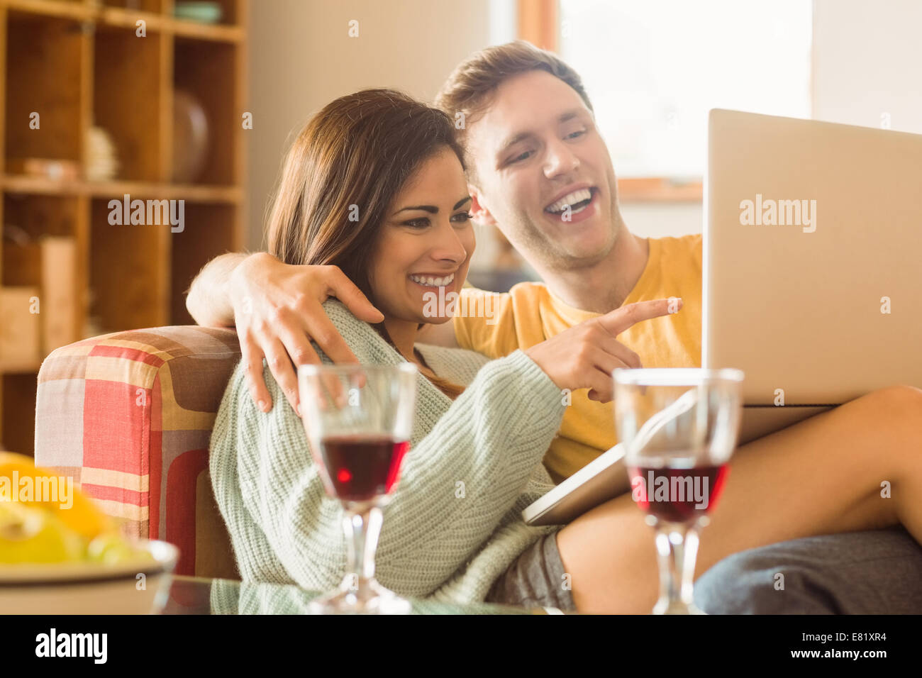 Young couple cuddling on the couch with laptop Stock Photo - Alamy