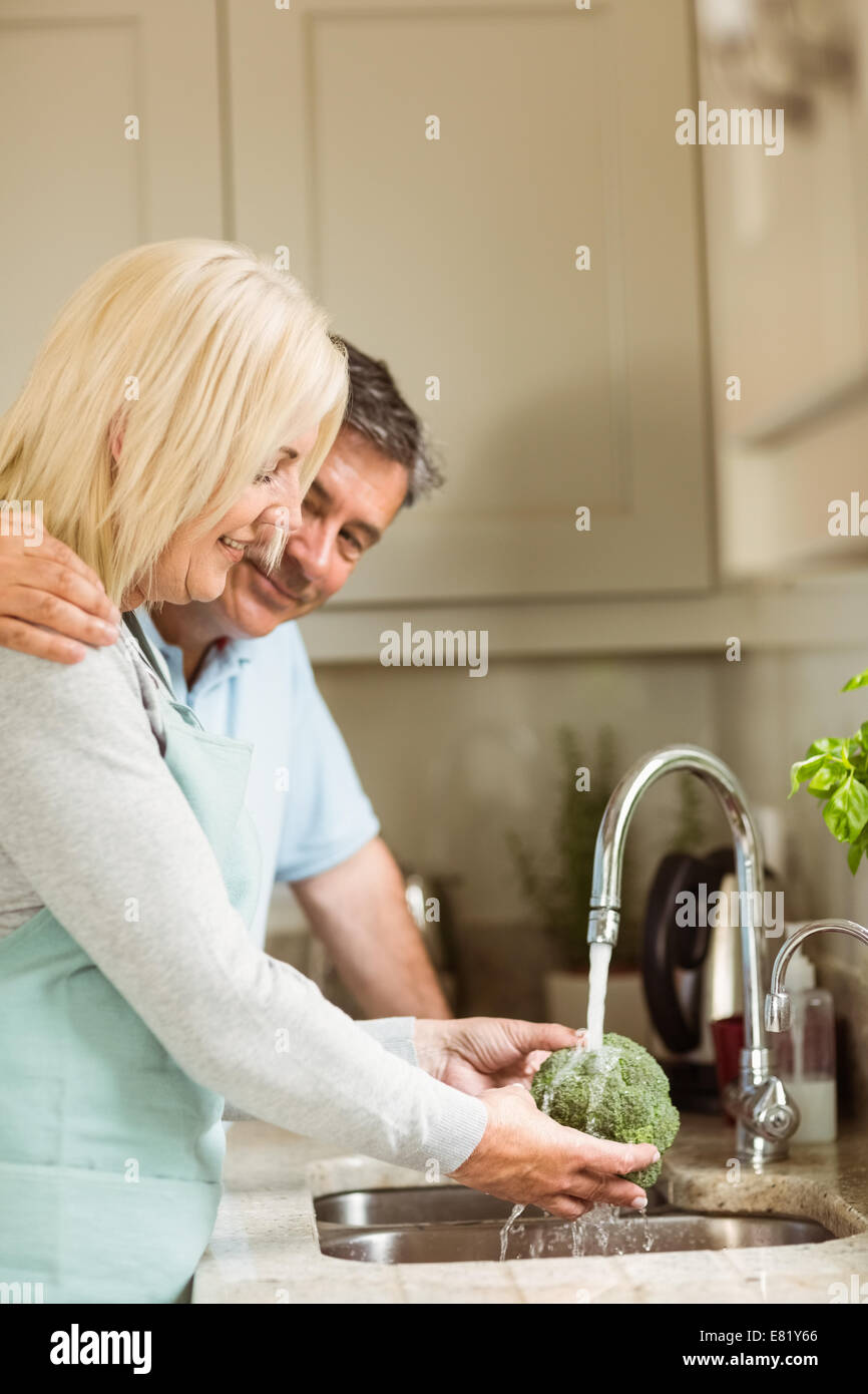 Happy mature couple washing broccoli Stock Photo