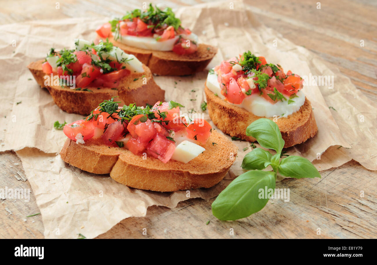 Bruschetta with fresh tomato, cheese and hrebs for breakfast Stock Photo