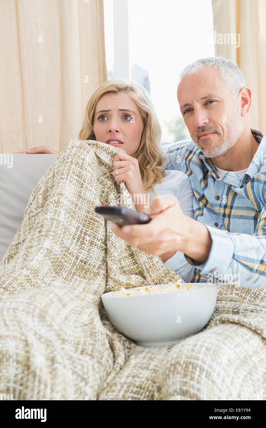 Happy couple watching a movie on the couch Stock Photo