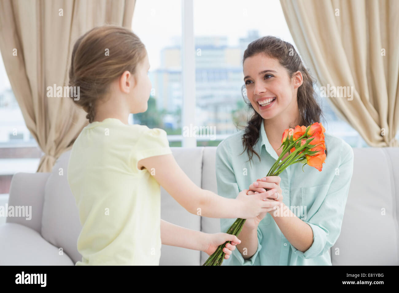 Cute girl giving flowers to mother Stock Photo Alamy