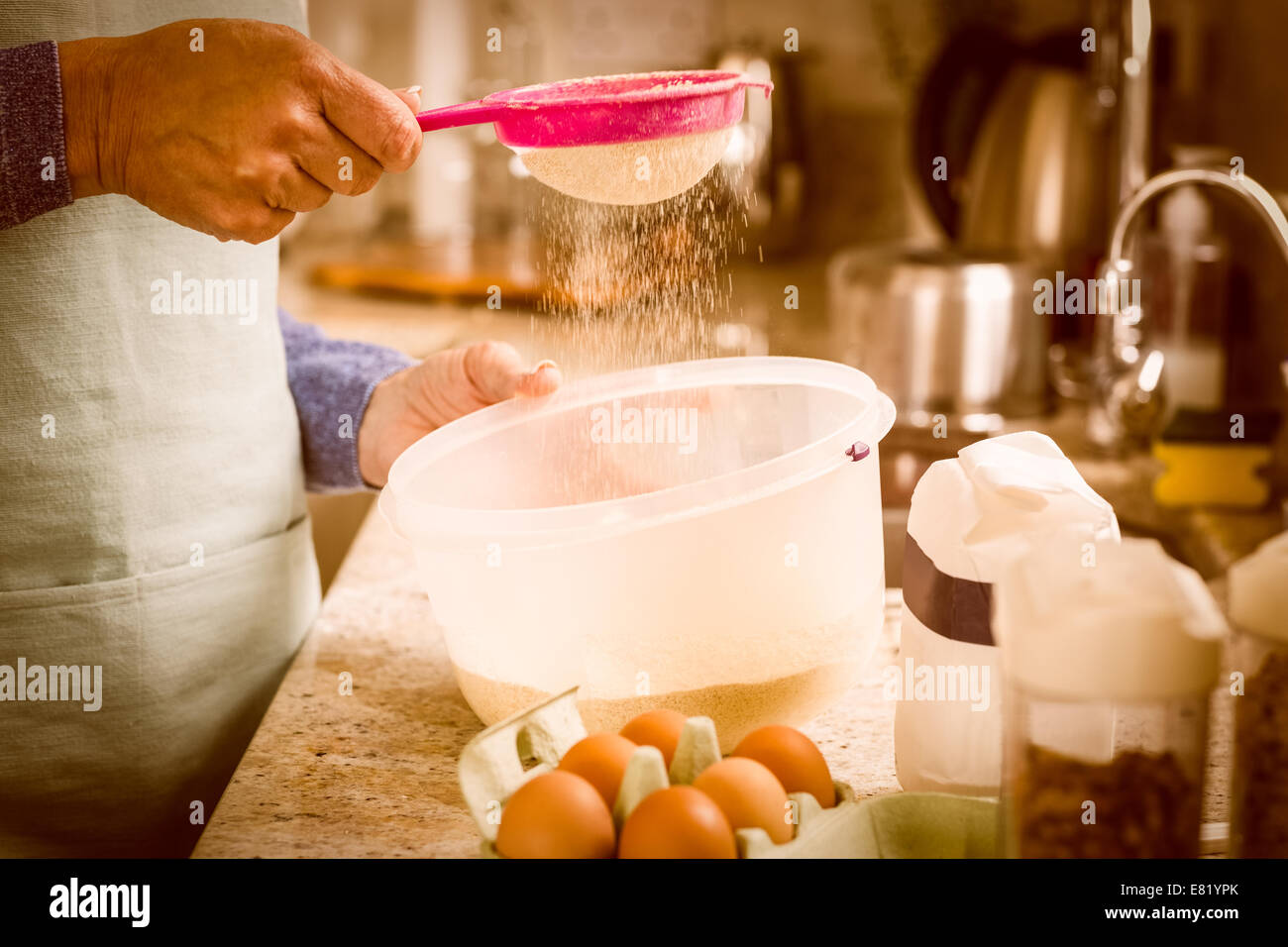 Woman sieving flour into bowl Stock Photo Alamy