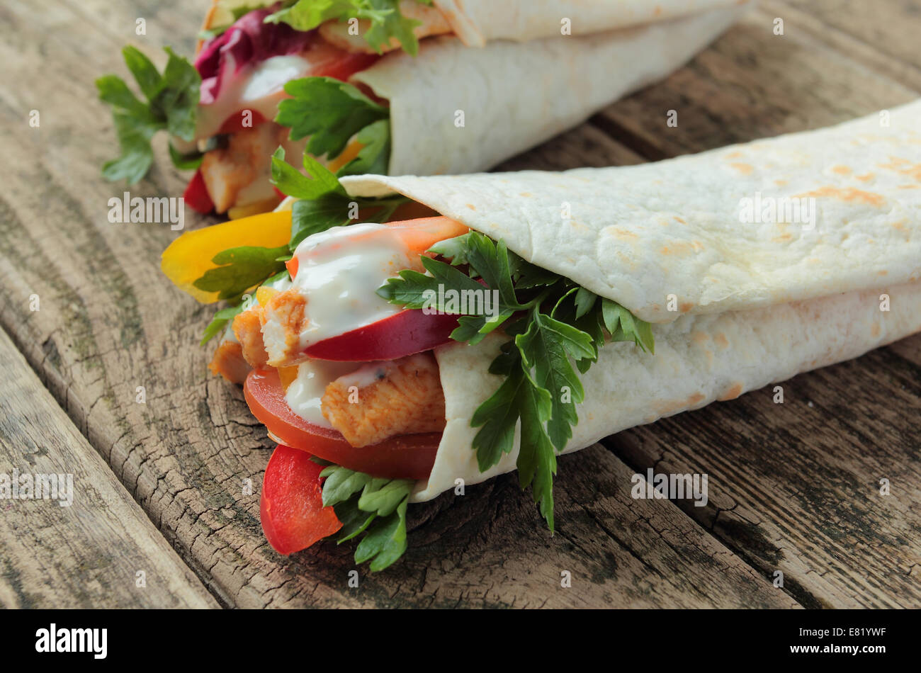 Wraps with chicken, garlic dressing and vegetables Stock Photo