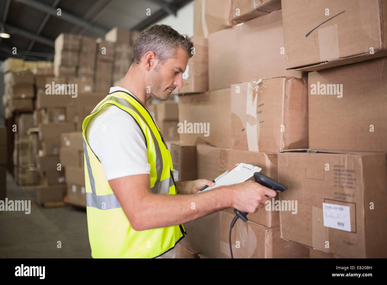 Worker scanning package in warehouse Stock Photo