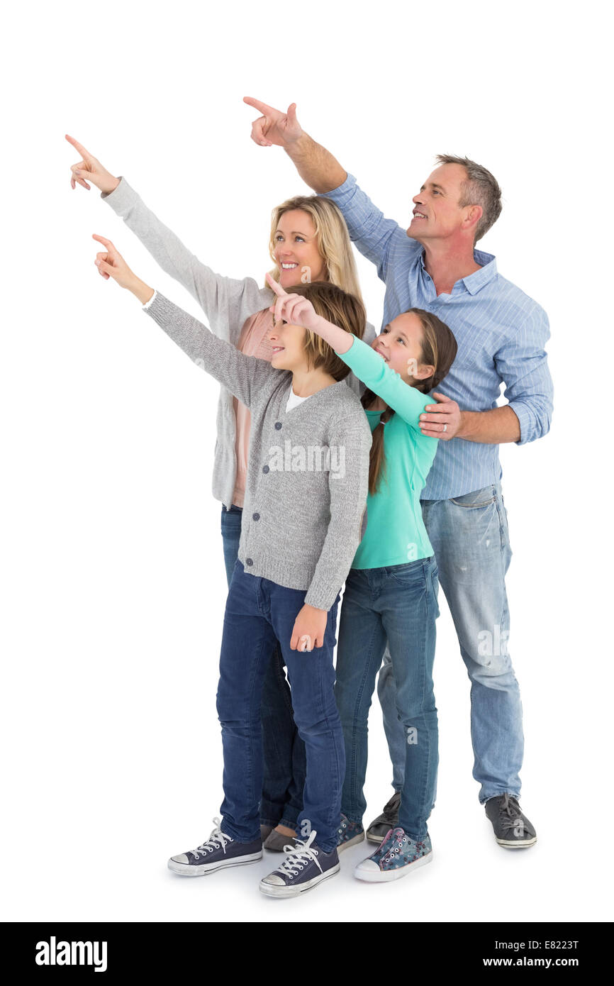 Happy family smiling and pointing at something Stock Photo