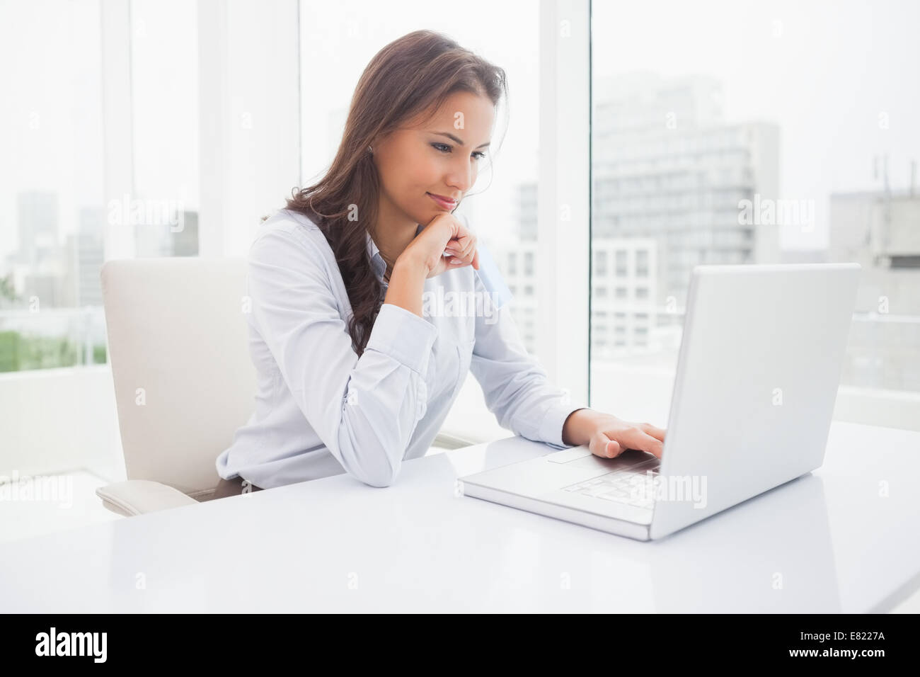 Happy businesswoman using laptop at her desk Stock Photo - Alamy