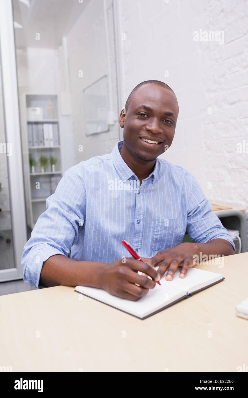 Portrait of a smiling businessman writing notes Stock Photo - Alamy