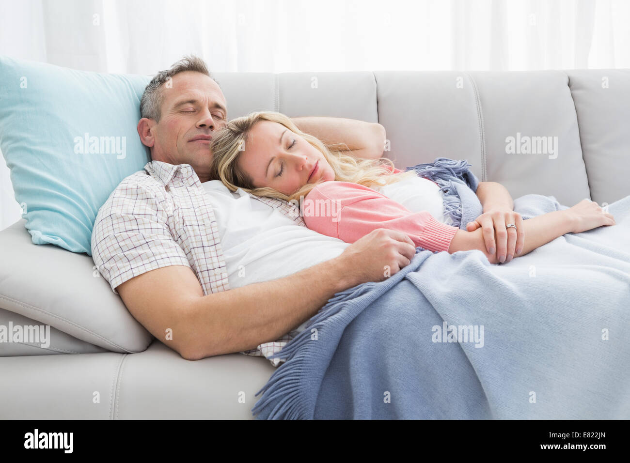 Cute couple napping under a blanket on the couch Stock Photo Alamy