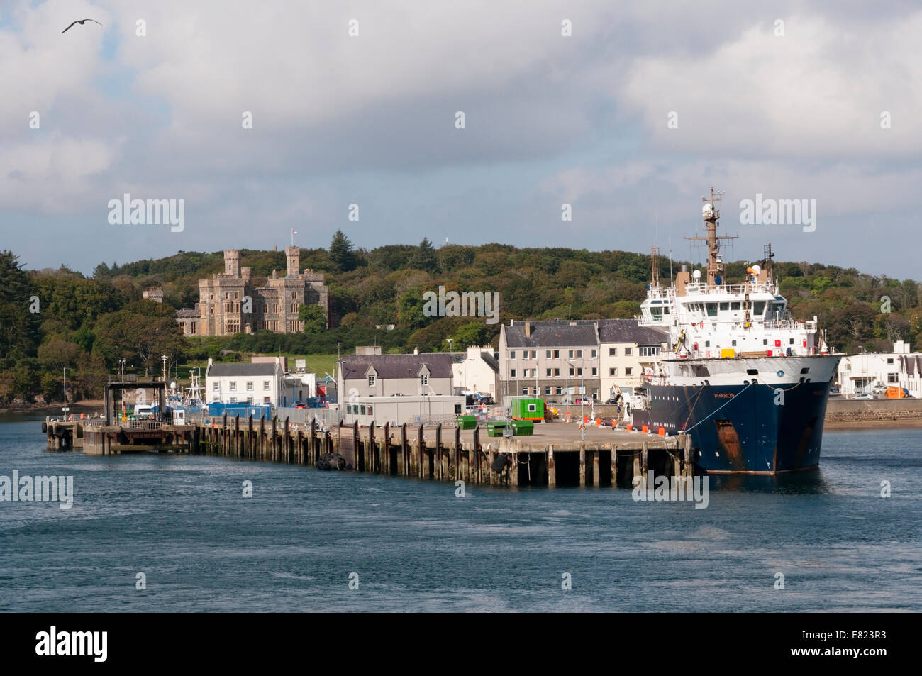 Stornoway Harbour with Lews Castle in background and the MV Pharos buoy laying vessel in port. Stock Photo