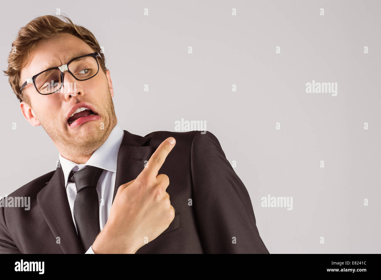 Young geeky businessman pointing to shoulder Stock Photo